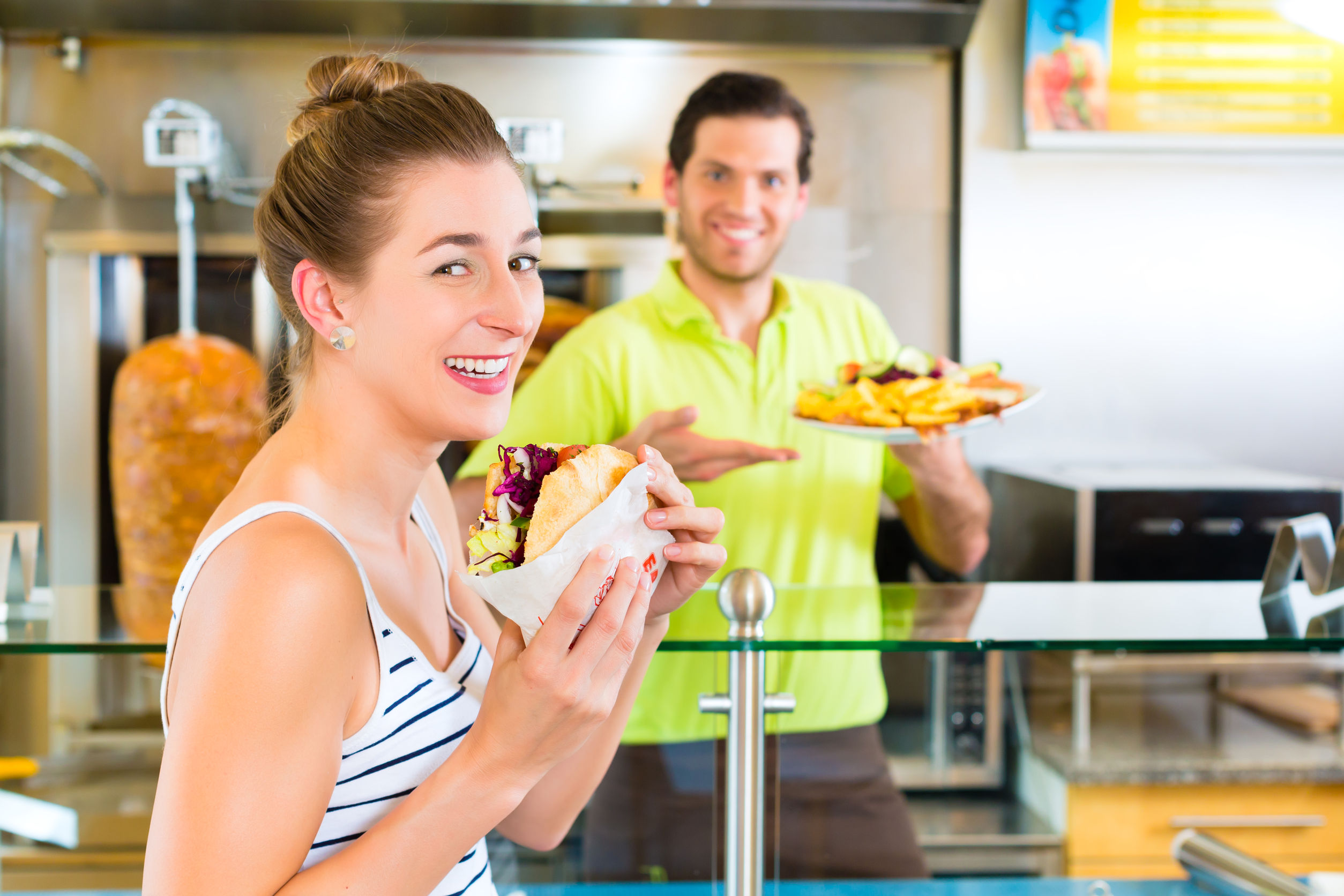 22880347_l-Doner-kebab-friendly-vendor-and-female-customer-in-a-Turkish-fast-food-eatery